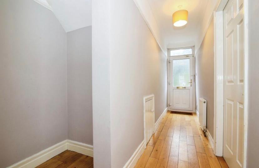 Bright, freshly painted hallway with wooden flo...