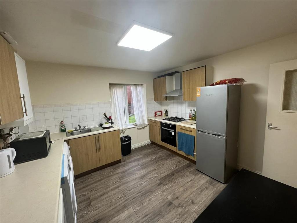 Well-lit kitchen featuring wooden cabinets, a m...
