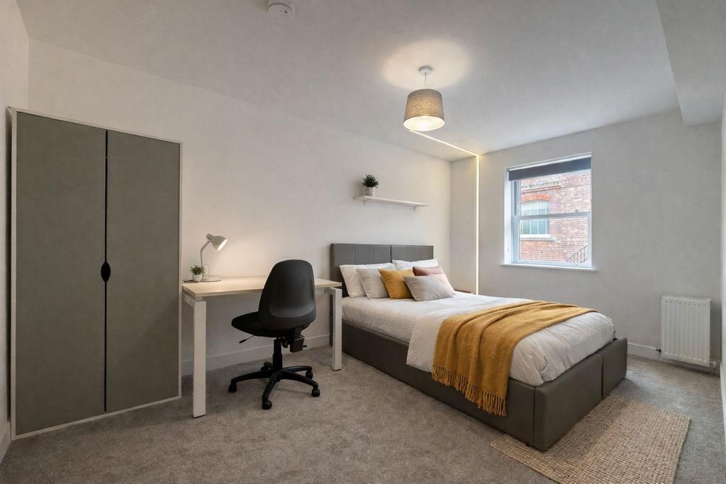 Bright, modern bedroom with desk and storage...