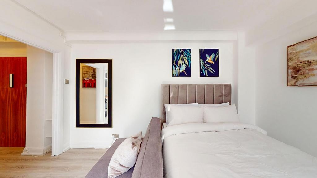 Bright, modern bedroom with a plush upholstered...