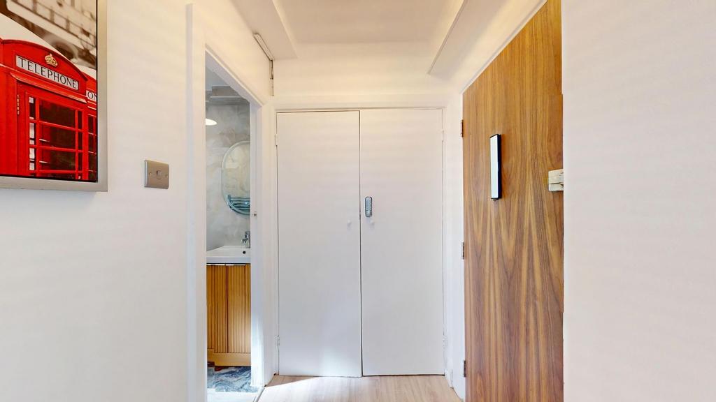 Bright, clean hallway with white walls, built-i...