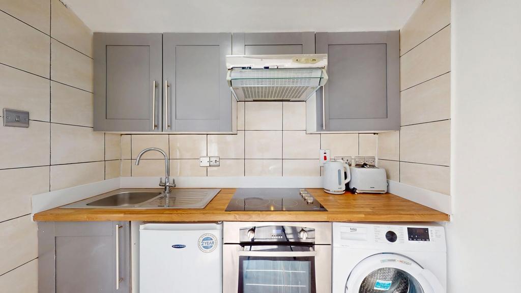 Compact modern kitchen with wood-effect worktop...
