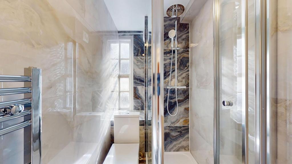 Bright, modern bathroom with a glass-enclosed s...