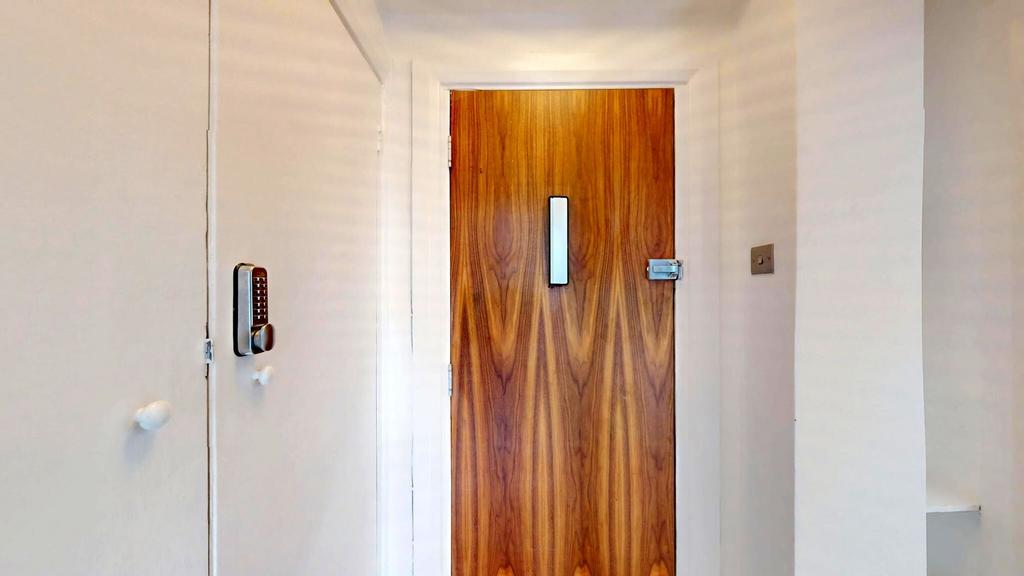 Bright, neutral hallway with a warm wooden inte...