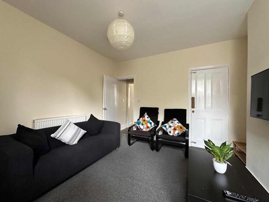 Bright, neatly presented living room with a com...