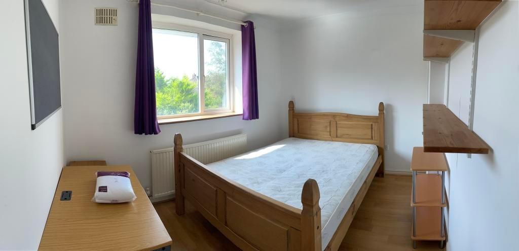 Bright, neatly presented bedroom with a wooden ...