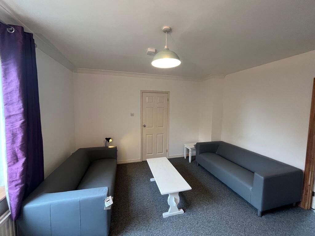 Bright communal lounge with two modern grey sof...