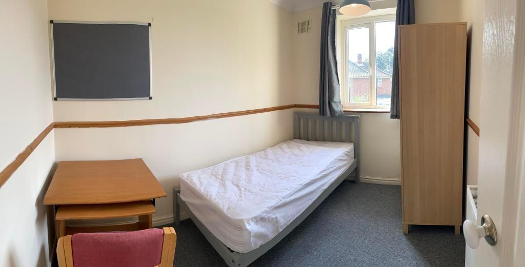 Neat single bedroom with a single bed, desk and...