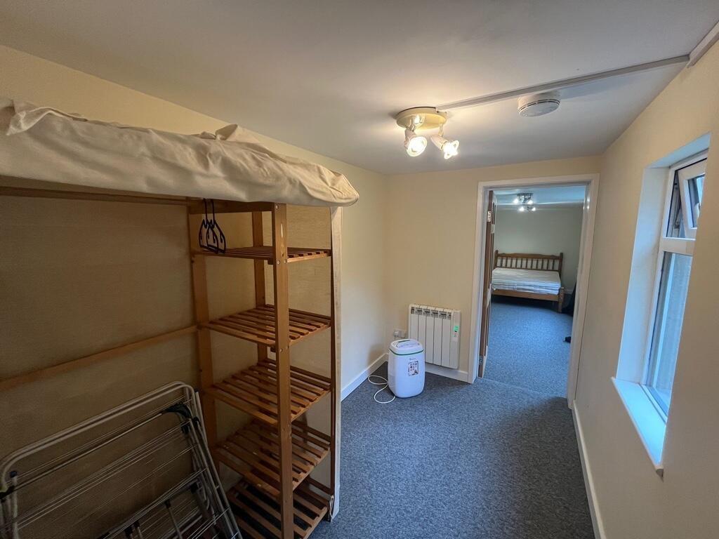 Bright, tidy hallway leading into a bedroom wit...
