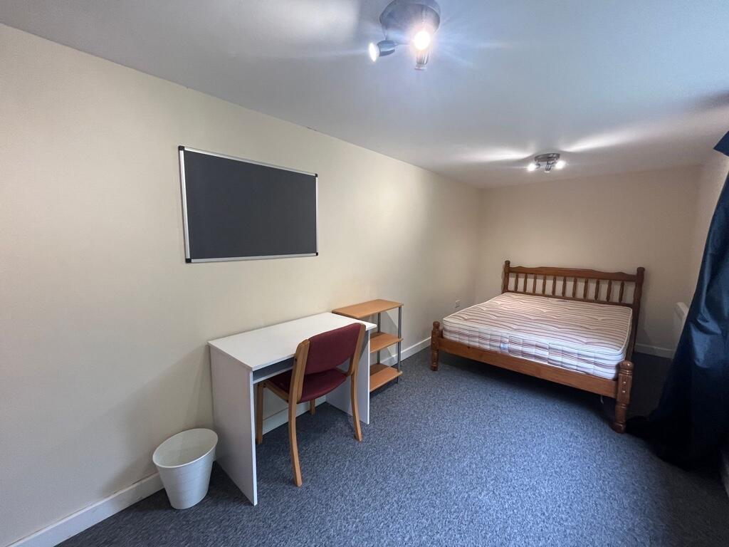 Bright, simply furnished bedroom with a wooden ...