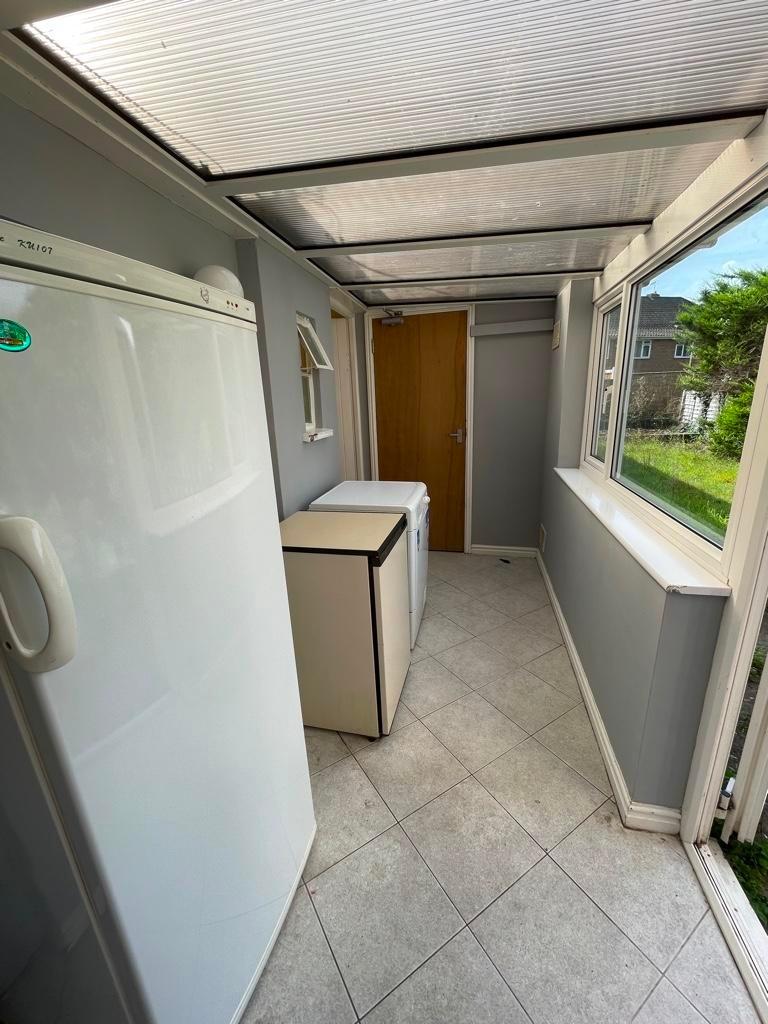 Bright enclosed porch/hallway with large window...