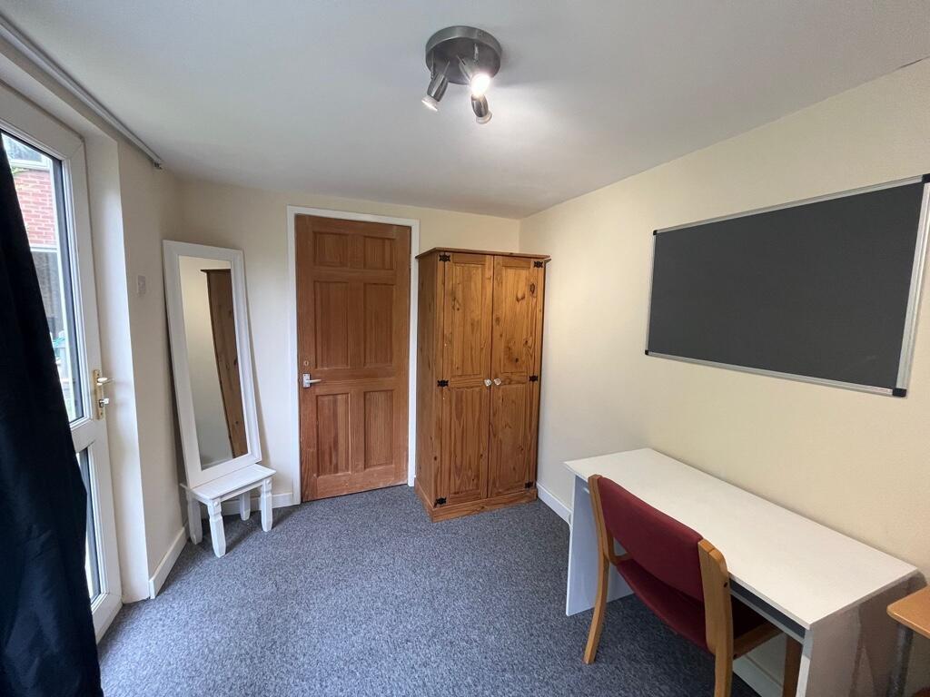 Bright, tidy single bedroom with a desk and cha...