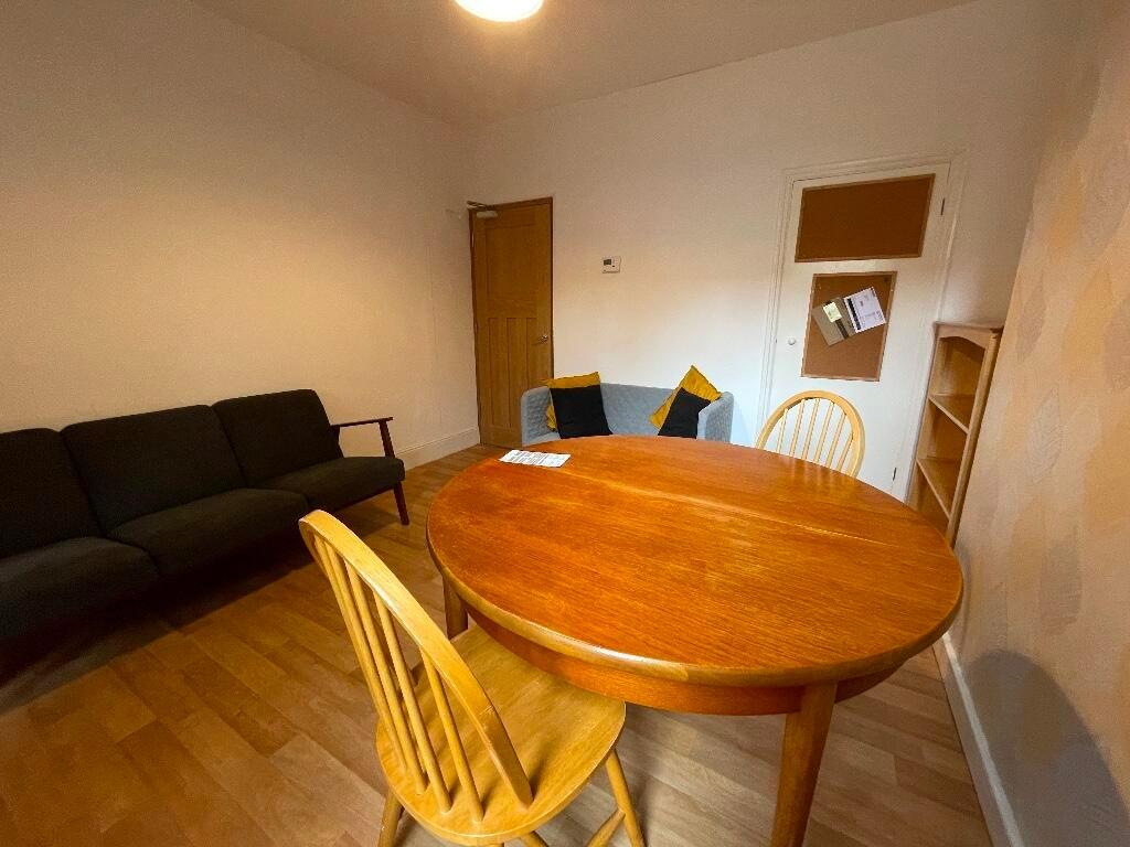 Warm communal living area with a round wooden d...