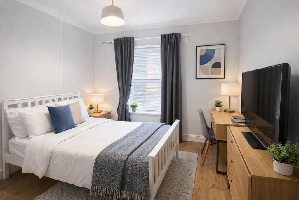 Bright, tidy bedroom with desk and TV...