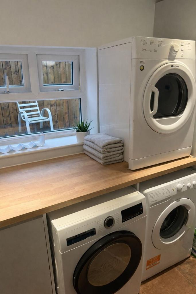Bright tidy laundry with countertop and machine...
