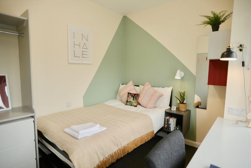 A bright and stylish bedroom featuring a cozy d...