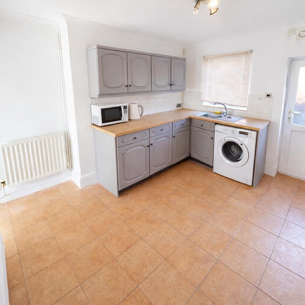 Bright, tidy kitchen with L-shaped counter, lig...