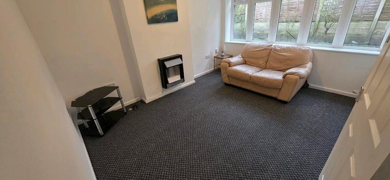 Bright living room with a large front window le...