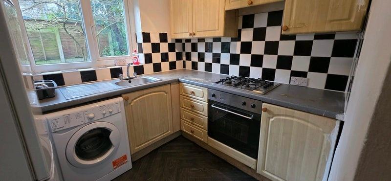 Neat fitted kitchen with L-shaped worktops, bui...