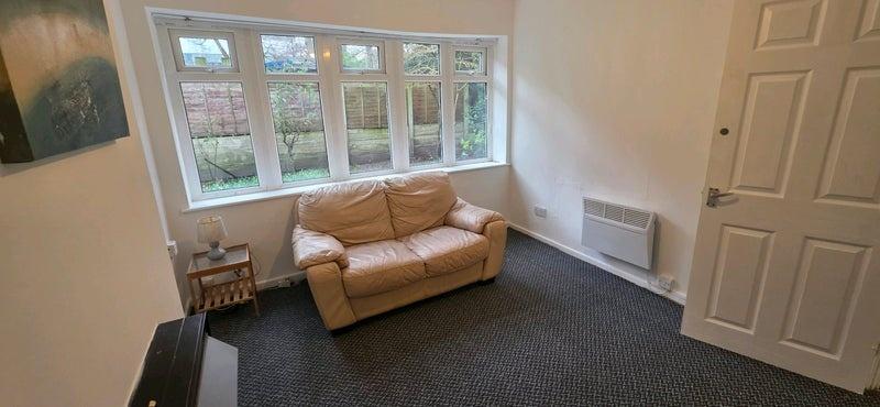 Bright, simply furnished living room with a lar...