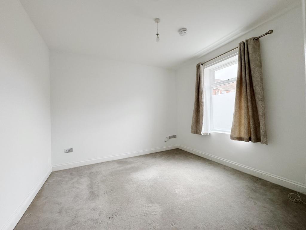 Bright, neutral bedroom with a large window, ne...