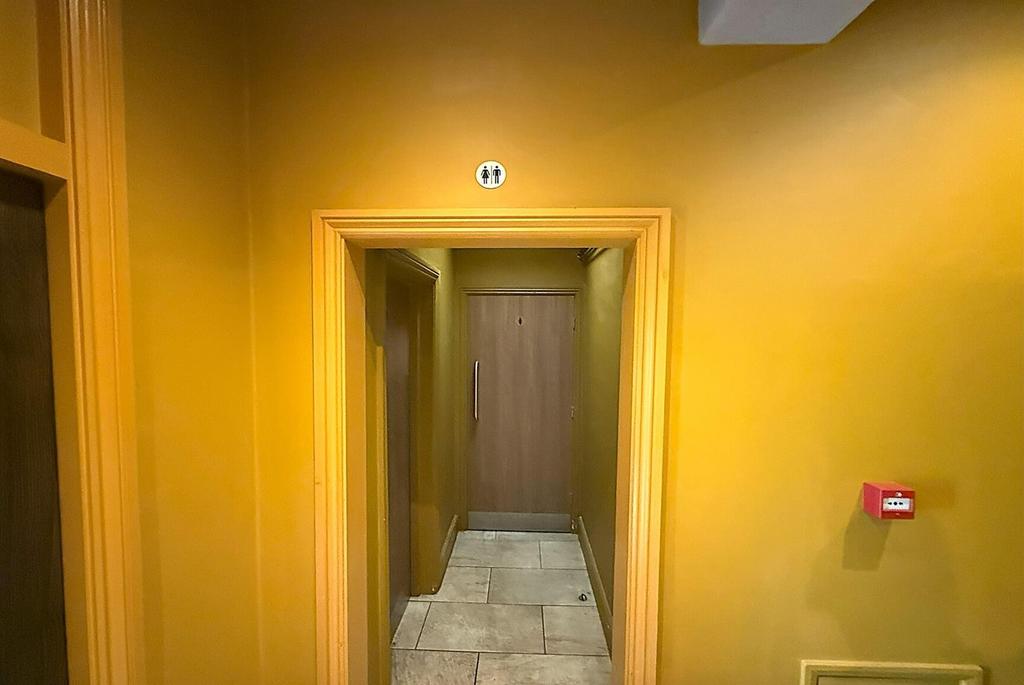 Bright yellow-painted communal corridor with ti...
