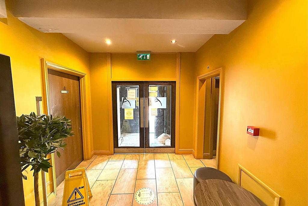 Bright communal hallway with tiled floors...
