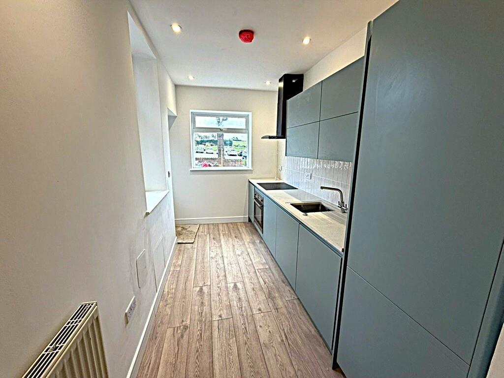Modern galley kitchen with fitted units and win...