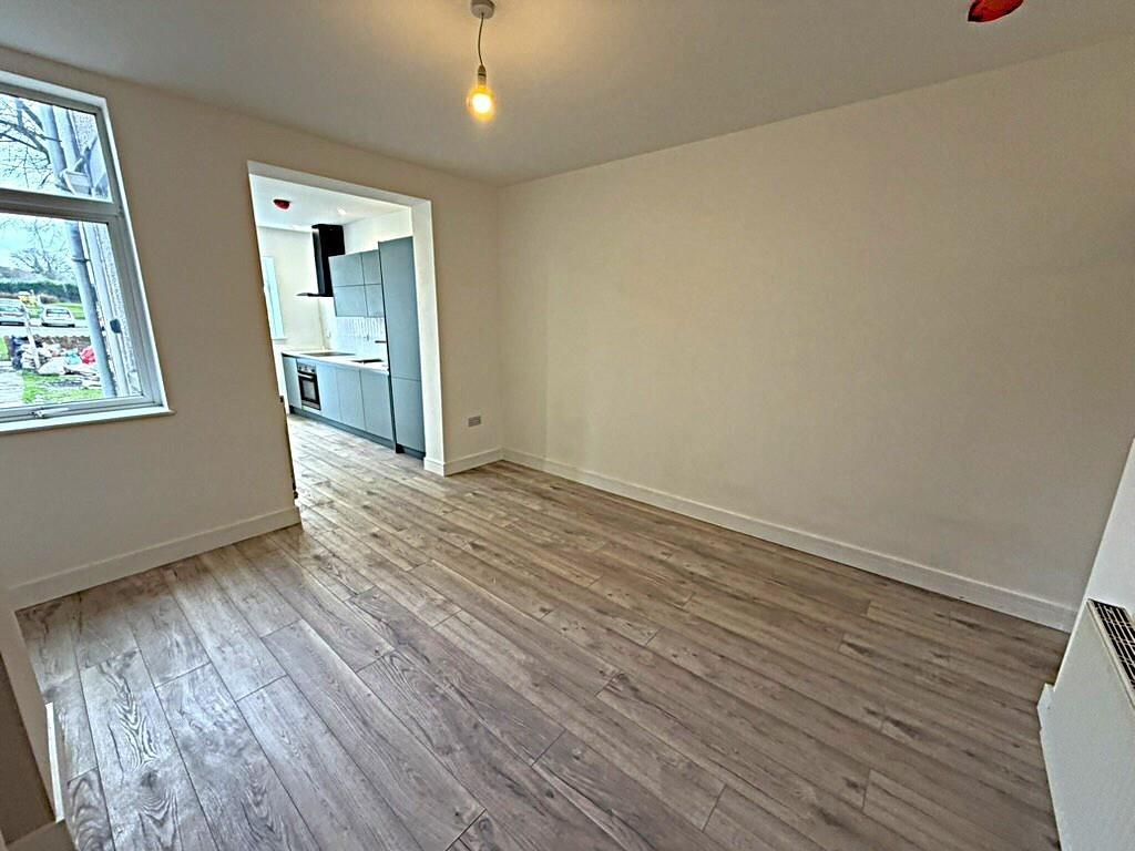 Bright living room with new flooring and window...