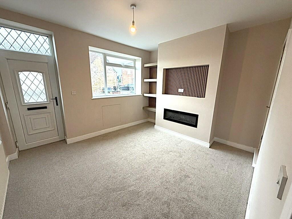 Bright, neutral living room with modern firepla...