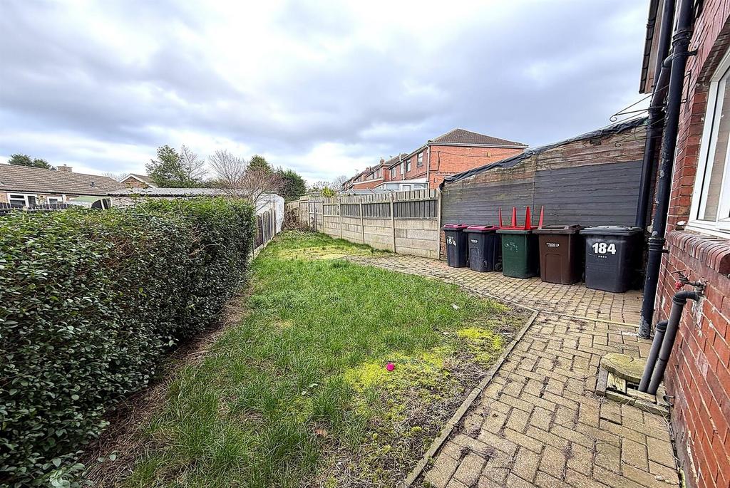 Private side garden with paved path and lawn...