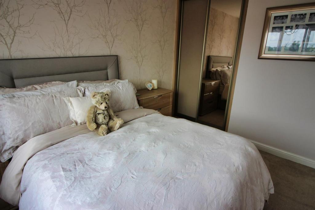 Cozy double bedroom with soft decor and bedside...