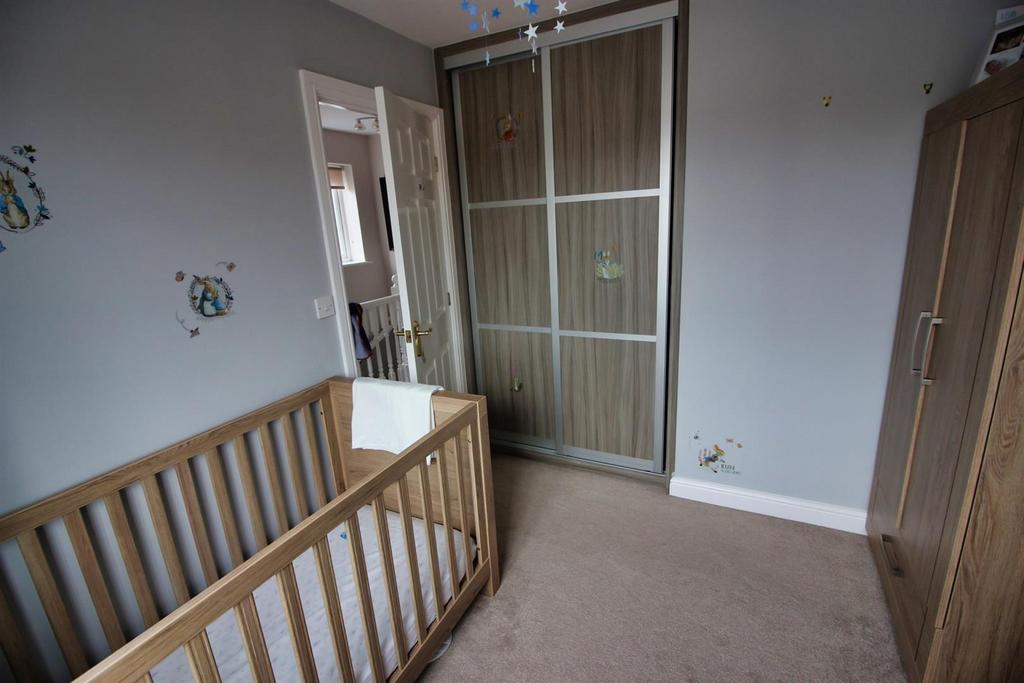 Bright bedroom with fitted storage and neutral-...