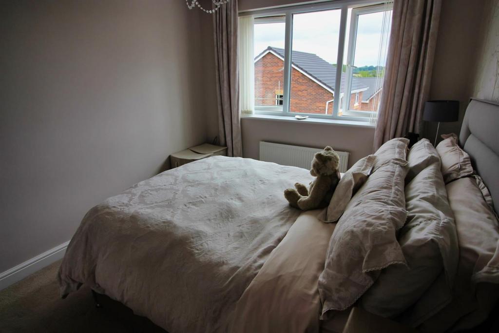 Cozy double bedroom with soft bedding and windo...