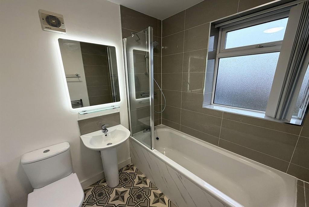 Modern bathroom with shower-over-bath and vanit...