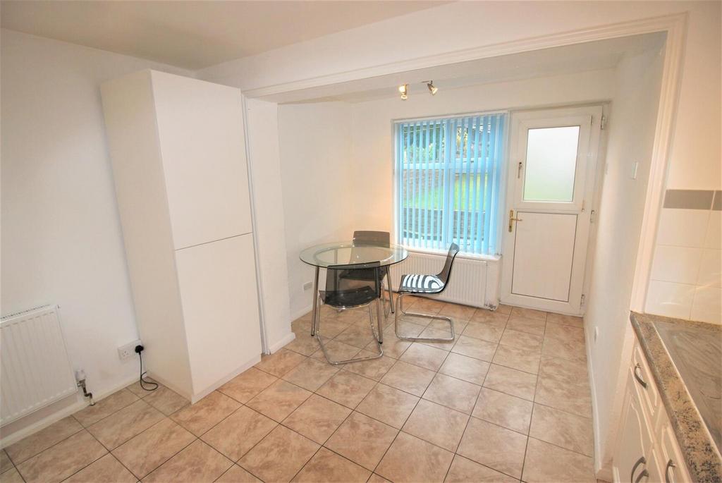 Bright tiled kitchen with dining spot and stora...