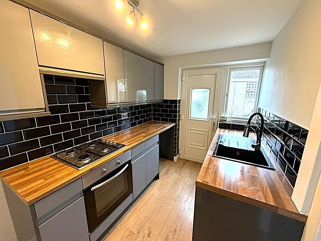 Modern galley kitchen with wood countertops...