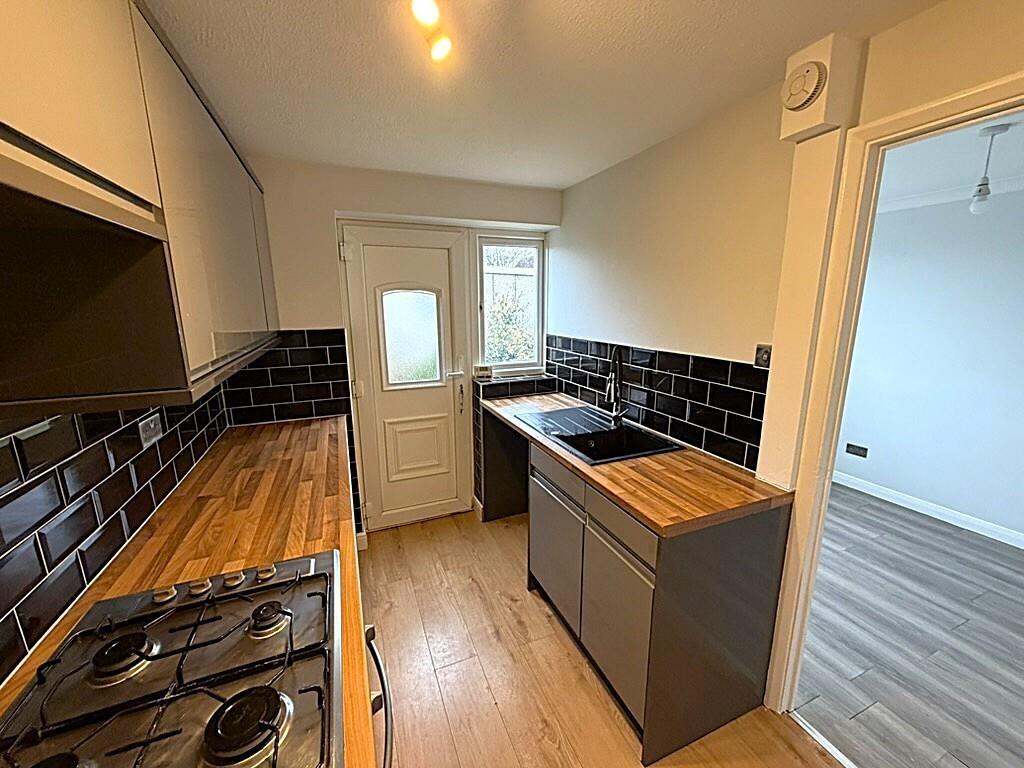 Modern galley kitchen with wood counters...