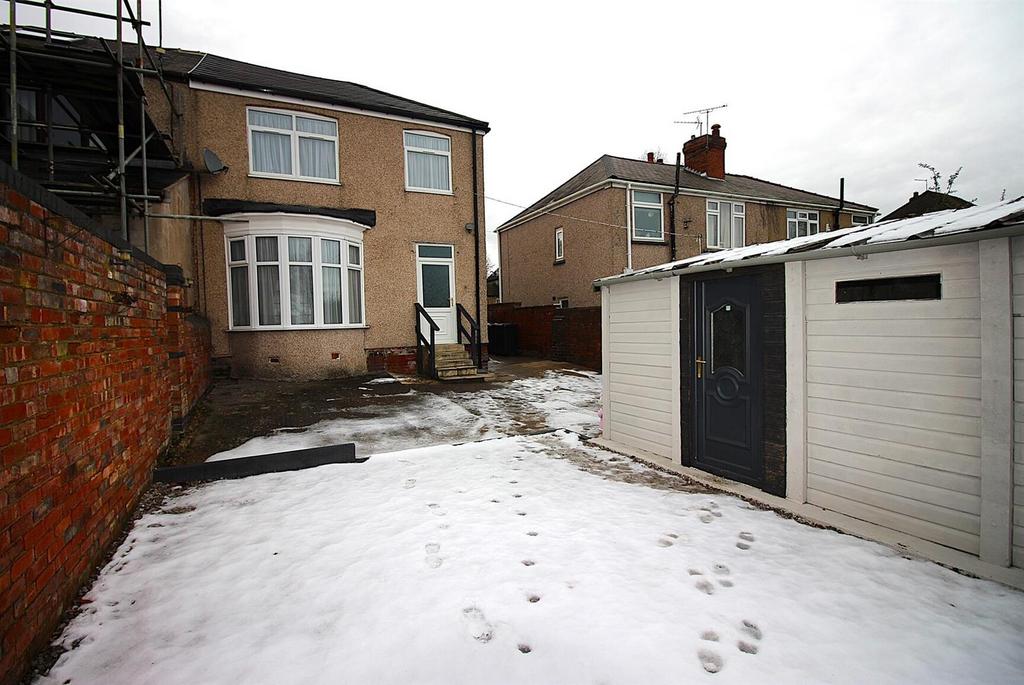 Snow-covered rear garden with outbuilding and y...