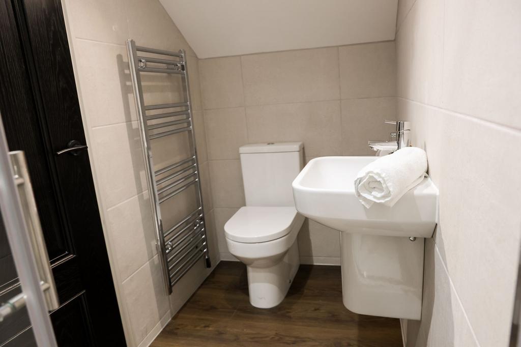 Modern tiled bathroom with white suite...
