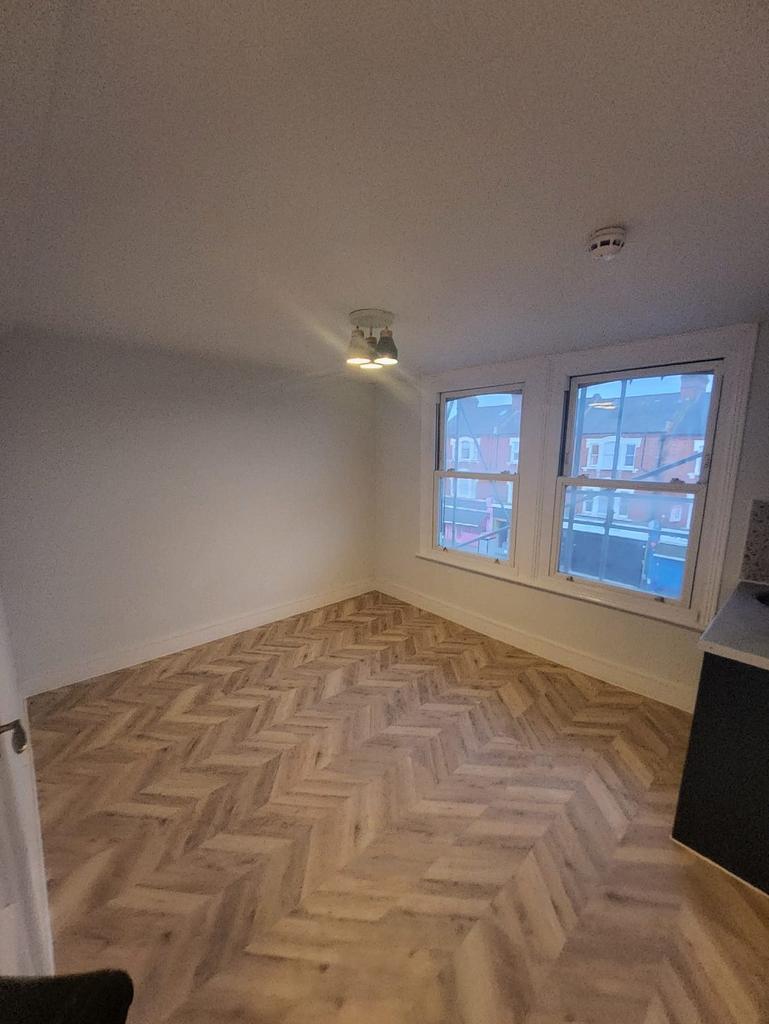 Bright room with patterned wood flooring and ba...