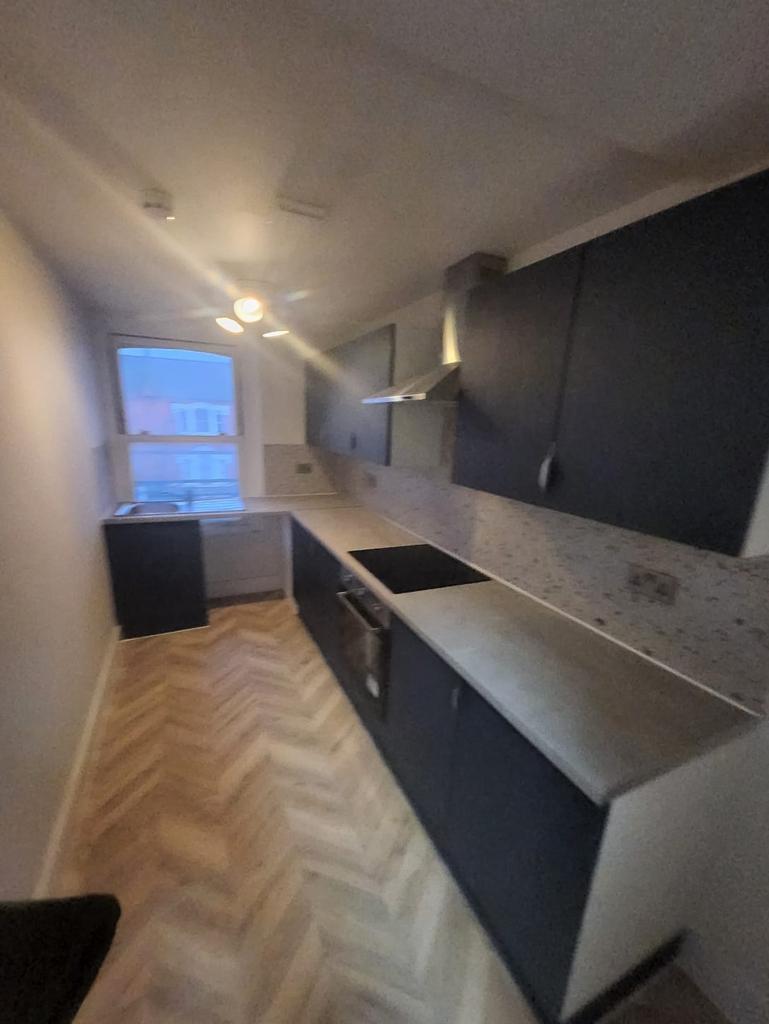 Long galley kitchen with fitted cabinets...