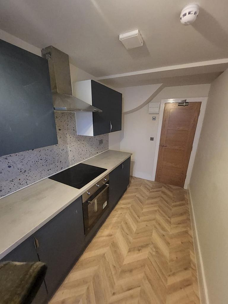 Sleek galley kitchen with herringbone floor...