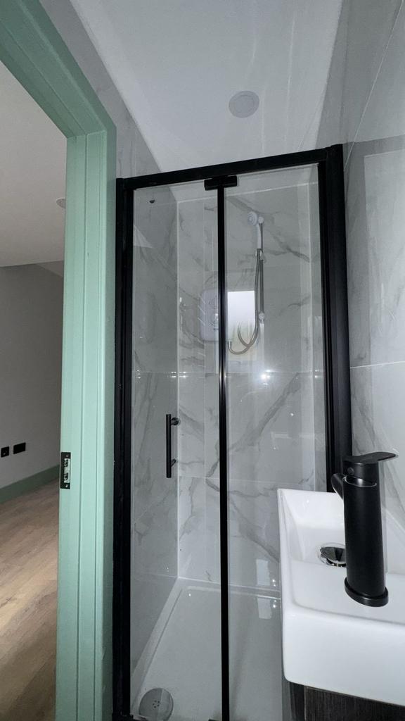 Modern shower cubicle with sleek black fittings...