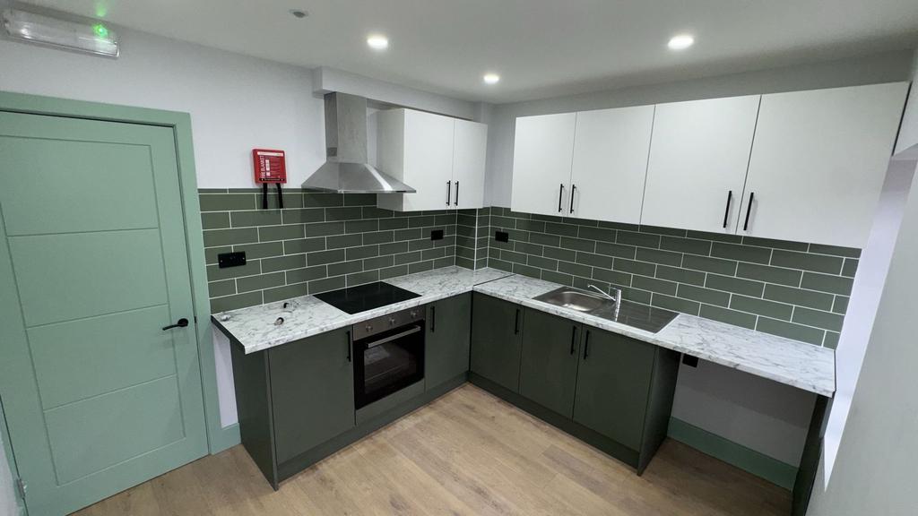 Contemporary L‑shaped kitchen with marble tops...