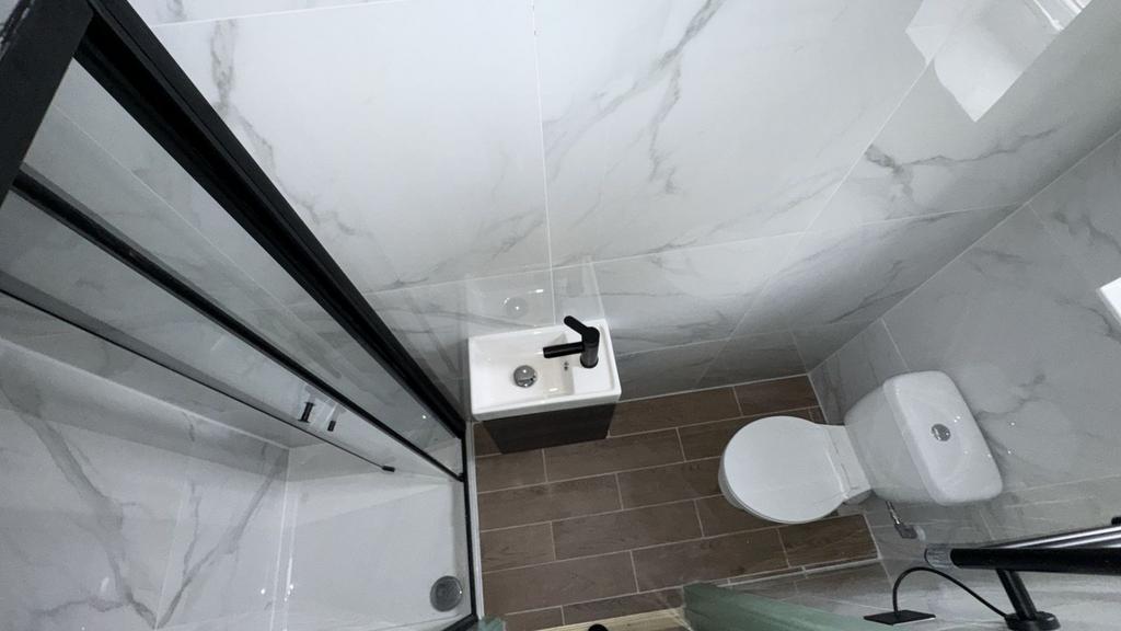 Modern tiled shower room with compact sink...
