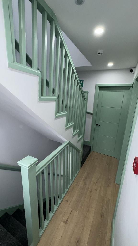 Bright hallway with painted mint balustrade...