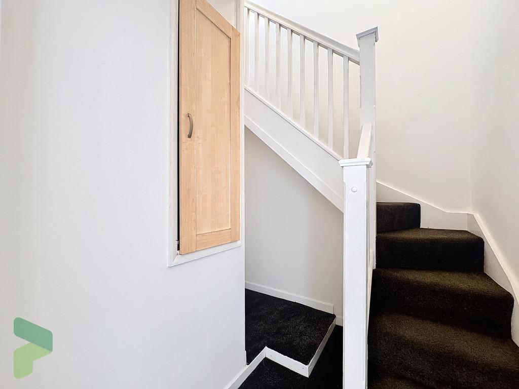 Carpeted staircase to attic