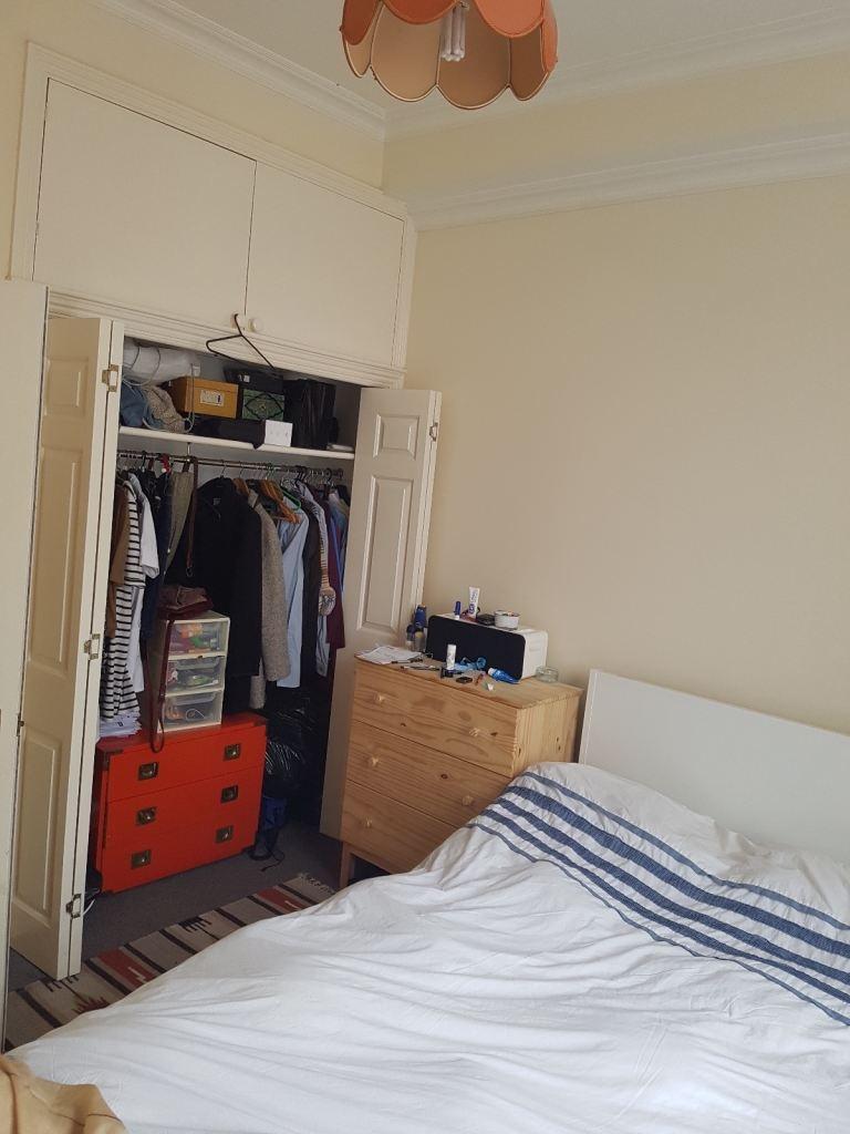 Bright bedroom with built-in wardrobe and stora...