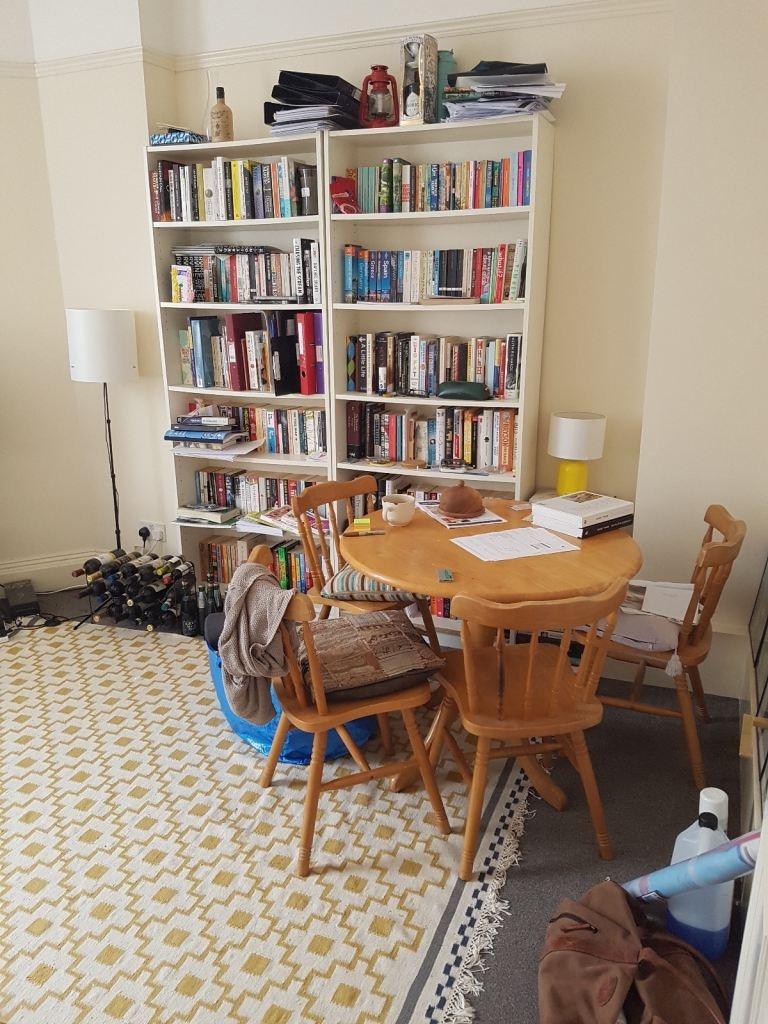 Cozy dining area with bookshelves and natural f...